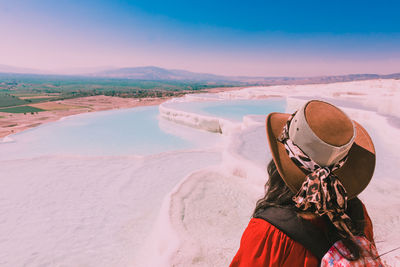 Person wearing hat on land against sky