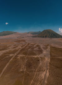 Scenic view of desert against blue sky