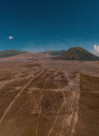 Scenic view of desert against blue sky