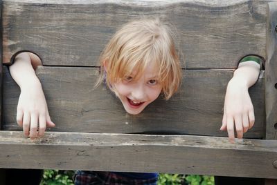 Portrait of cheerful girl trapped in pillory