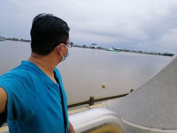 Rear view of man in sea against sky