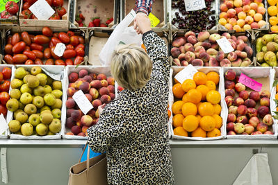 High angle view of woman buying vegetables at market stall