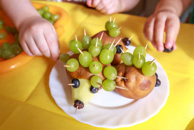High angle view of hand holding fruit on table