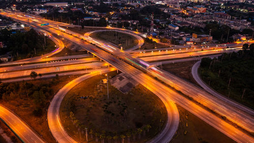 Aerial view of circle road traffic in roundabout and highway at night long exposure shot from drone