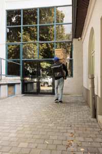 Rear view of woman walking on footpath