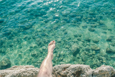 Low section of man relaxing in swimming pool