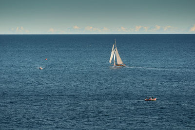 Sailboat sailing on sea against sky