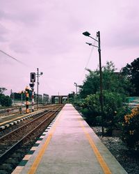 Railroad tracks by trees against sky