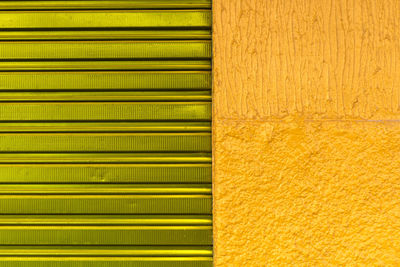 Texture pattern of green iron door of closed store and yellow wall in brazil