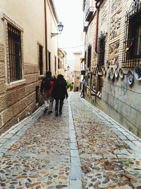 People walking on footpath amidst buildings in city