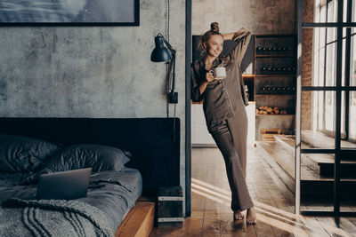 Woman standing against wall at home