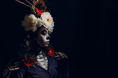 Portrait of woman wearing mask against black background