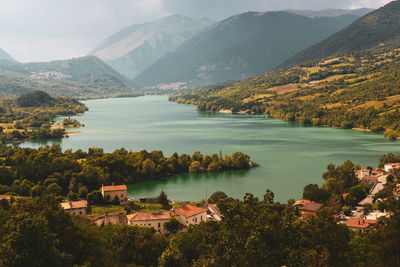 High angle view of lake and buildings against mountains