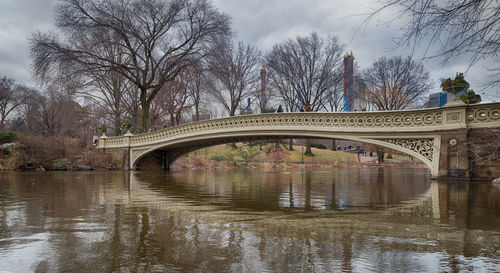 Arch bridge over river against sky