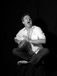 Man sitting against black background