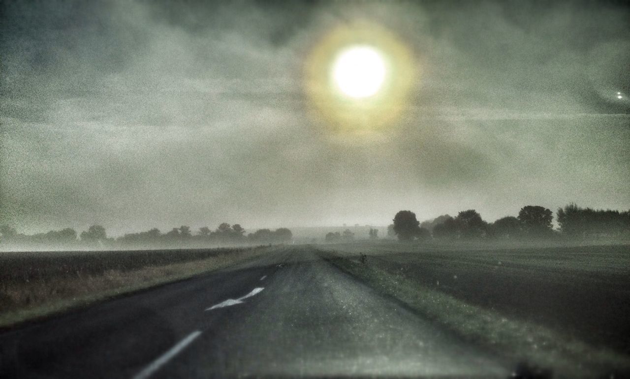 transportation, road, the way forward, sky, diminishing perspective, weather, vanishing point, cloud - sky, nature, windshield, road marking, landscape, no people, sun, tranquility, street, country road, outdoors, tranquil scene, beauty in nature