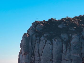 Low angle view of rock formation against clear blue sky