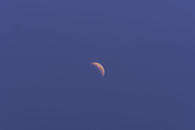 Low angle view of moon against clear blue sky