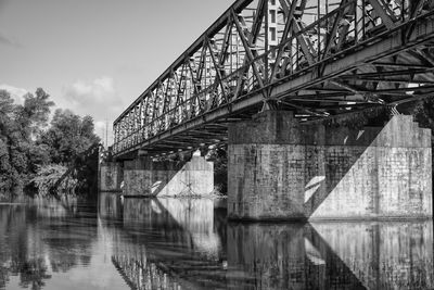 Arch bridge over river against sky