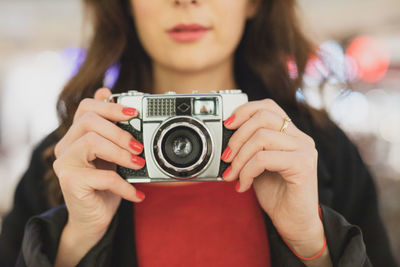 Midsection of woman holding camera
