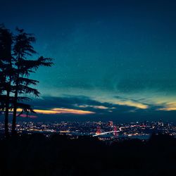 Illuminated cityscape against sky at night