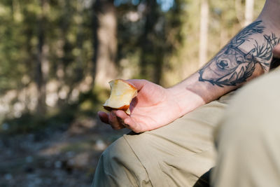 Close-up of inked male arm holding an apple