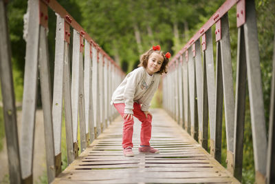 Portrait of girl standing on footbridge