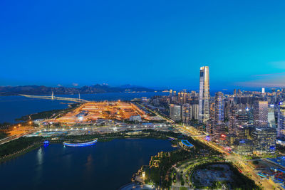 High angle view of city lit up at waterfront