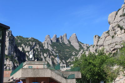 Panoramic shot of buildings and mountains against clear blue sky