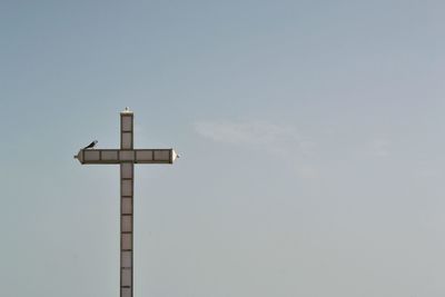 Low angle view of cross against sky