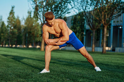 Full length of young man sitting on grass