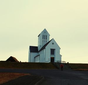 Building by road against clear sky