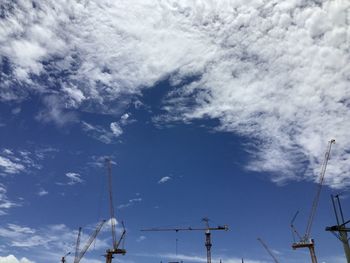 Low angle view of cranes against sky