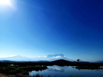 Scenic view of snowcapped mountains against blue sky