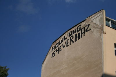 Low angle view of information sign against blue sky