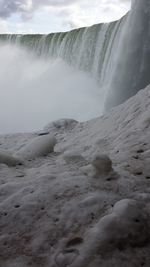 Scenic view of waterfall against sky