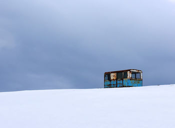 Abandoned vehicle on snow covered landscape