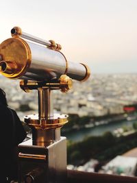 Close-up of coin-operated binoculars against buildings in city