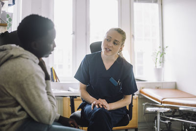 Female nurse advising male patient during visit at hospital