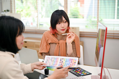 Young woman using phone while sitting at home