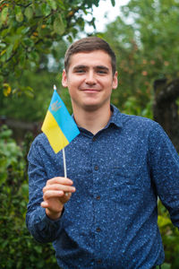 Ukrainian man. young smiling man holding ukrainian flag. no war. support for ukraine. patriotic 