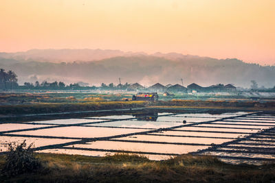 Scenic view of agricultural field against sky during sunset