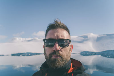 Portrait of young man wearing sunglasses against sky