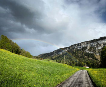 Road leading towards mountains against sky