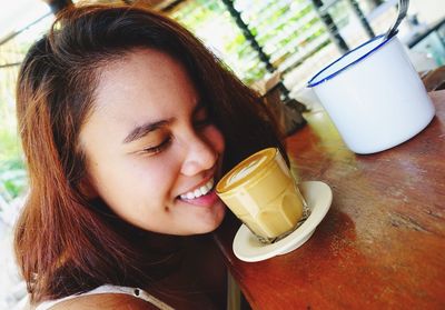 Close-up of young woman drinking glass with drink on table