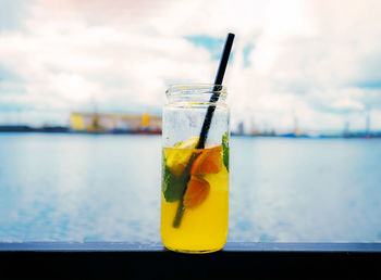 Close-up of drink on glass against blurred background at the docks.