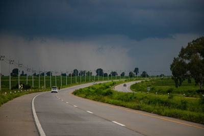 Road amidst field against sky