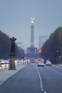 Statue in city against clear sky