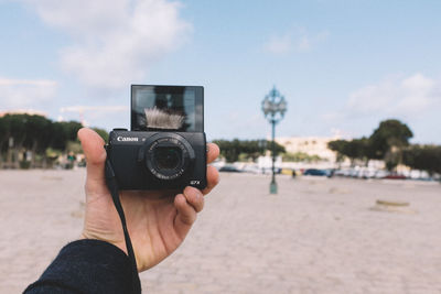 Cropped image of man photographing through camera