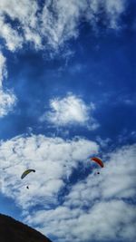 Low angle view of person paragliding against sky